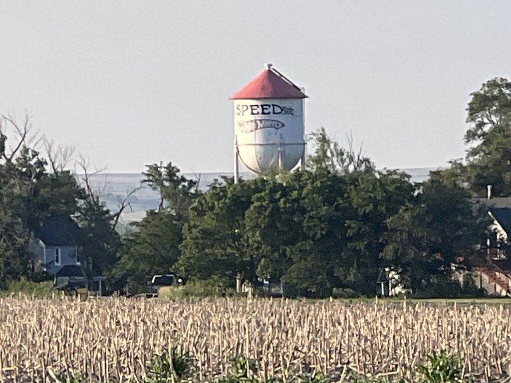 Old water tower in Speed, Kansas, with the words “Speed Kansas” and “Hot Wheels” painted on it