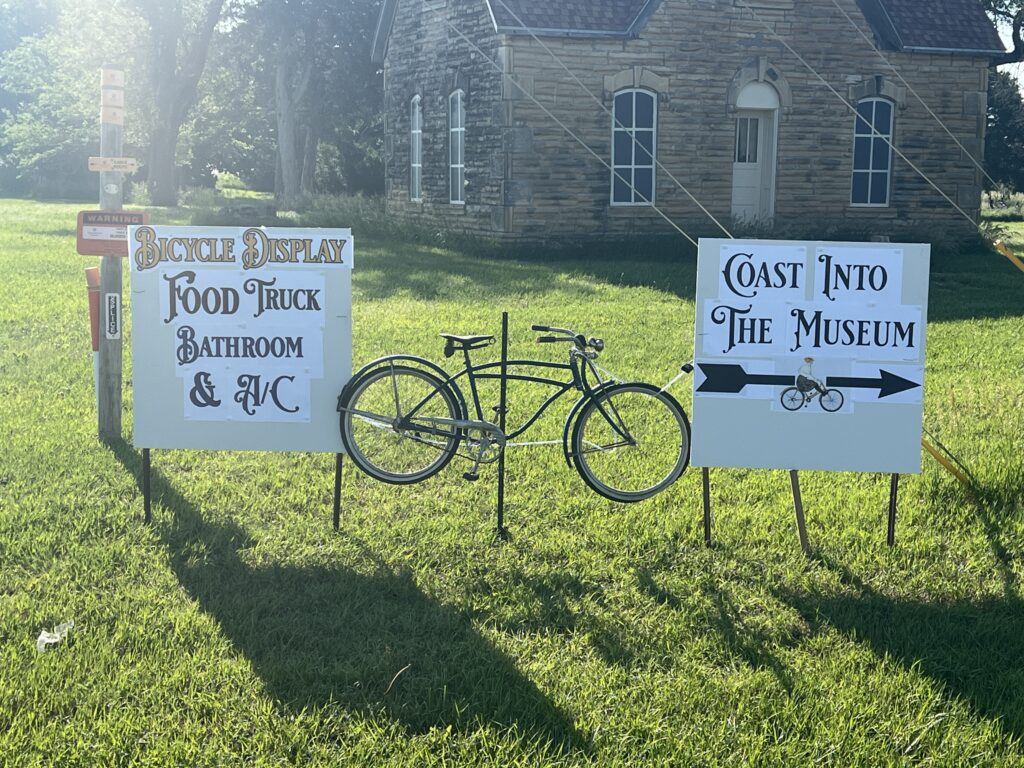 A classic bicycle displayed proudly with Bike Across Kansas (BAK) signs in the background, capturing the spirit of the ride and the milestone celebration.