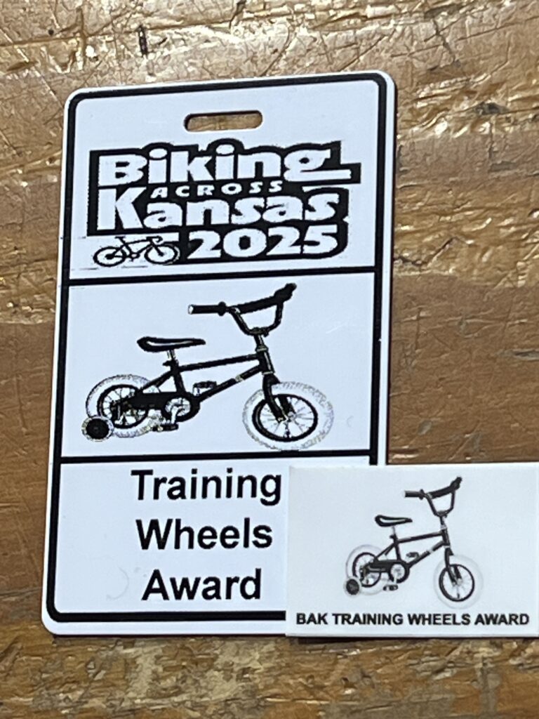 Photo of the BAK 2025 Training Wheels Award badge presented to Rob, featuring bold lettering on a metal plaque.