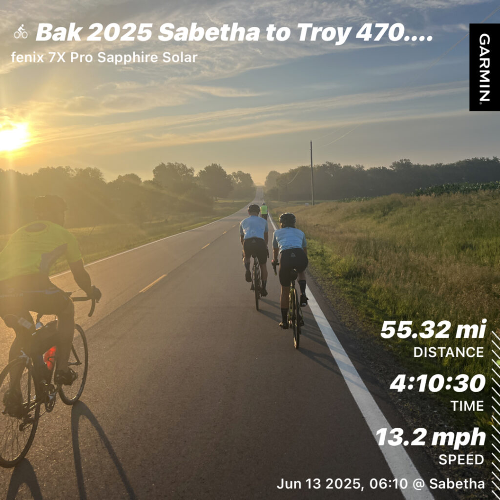 Three cyclists riding toward the horizon with the sun glowing behind them