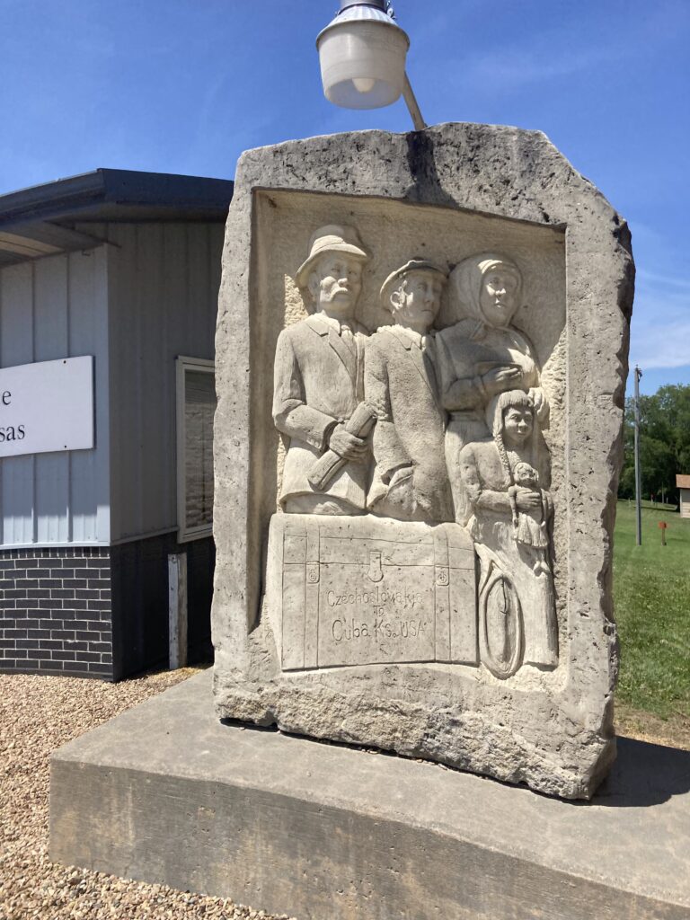 Granite statue in Cuba, Kansas depicting a Czech immigrant family arriving at a train station in the late 1800s, honoring the town’s Czech heritage.