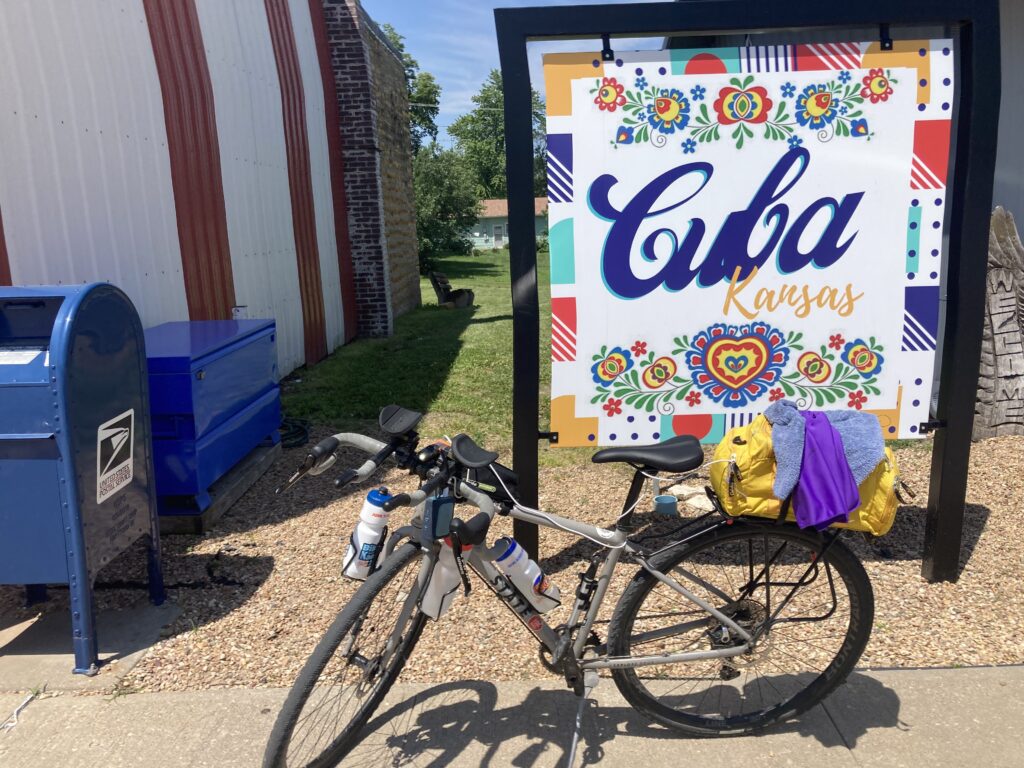 Bicycle parked in front of the Cuba, Kansas town sign on Day 5 of Biking Across Kansas, marking a quick stop on the route.