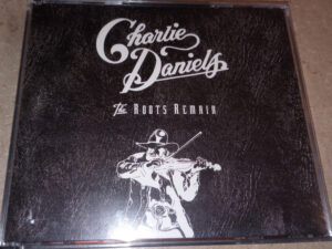 Charlie Daniels “Roots Remain” box set album cover showing a classic rustic design with an acoustic guitar.