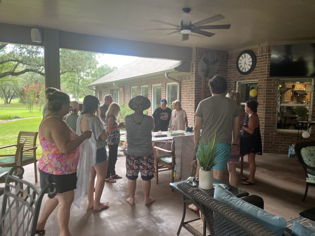 Stepdad Charles cutting his 80th birthday cake surrounded by family at Bryan, Texas celebration.