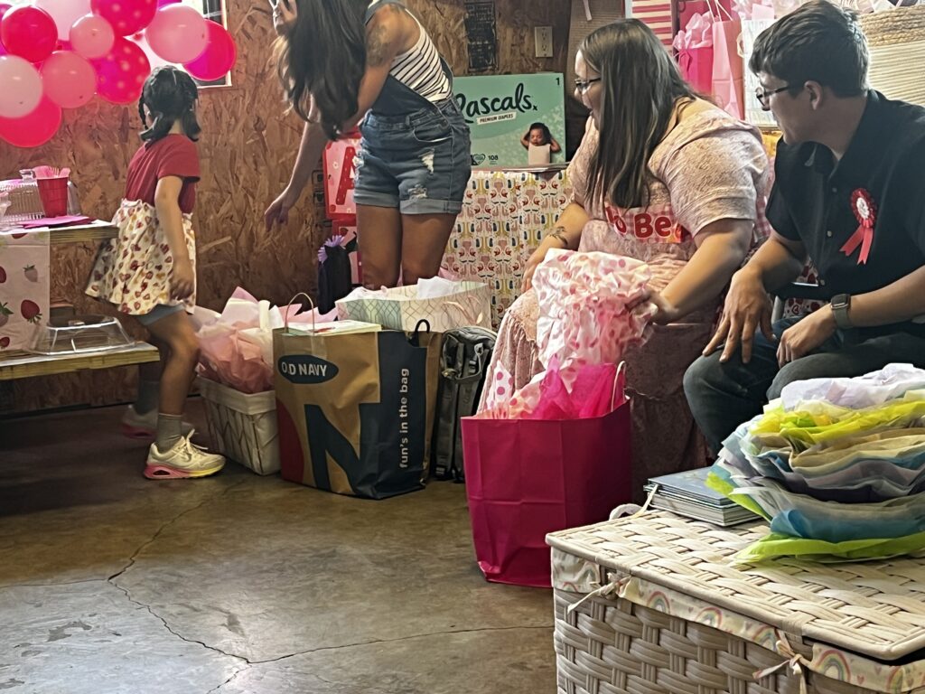 Marla and Brylan looking back at the pile of gifts at Baby Brinlee’s ShauneNation baby shower.
