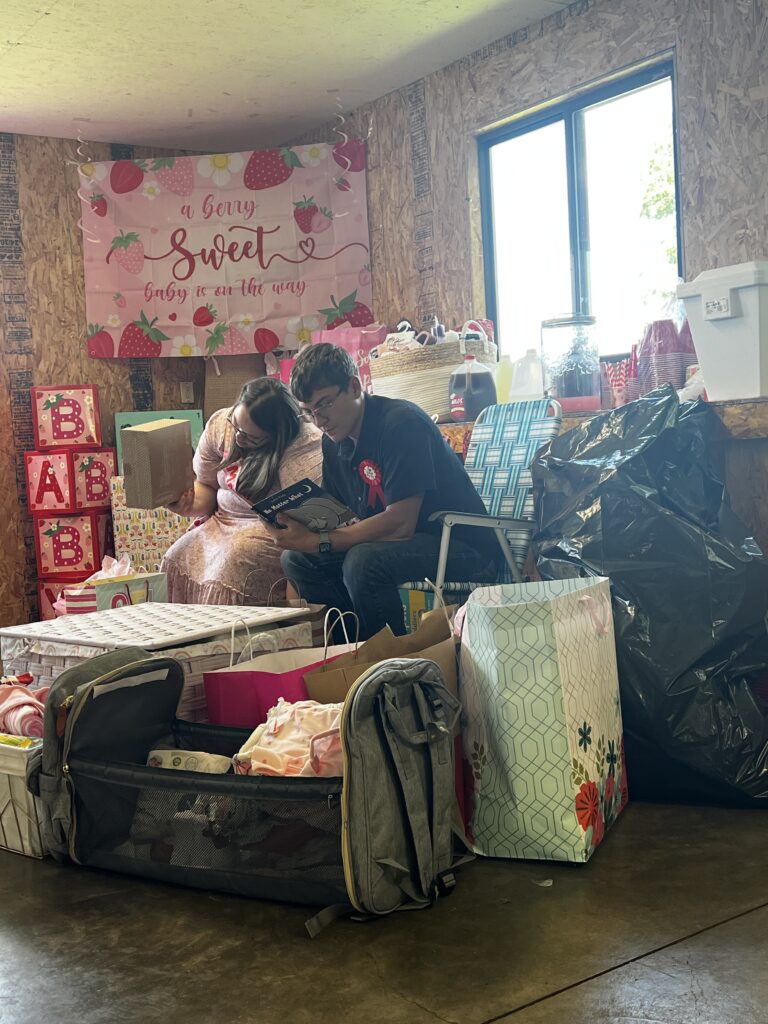 Brylan focused on reading a heartfelt card at the ShauneNation baby shower for Baby Brinlee.
