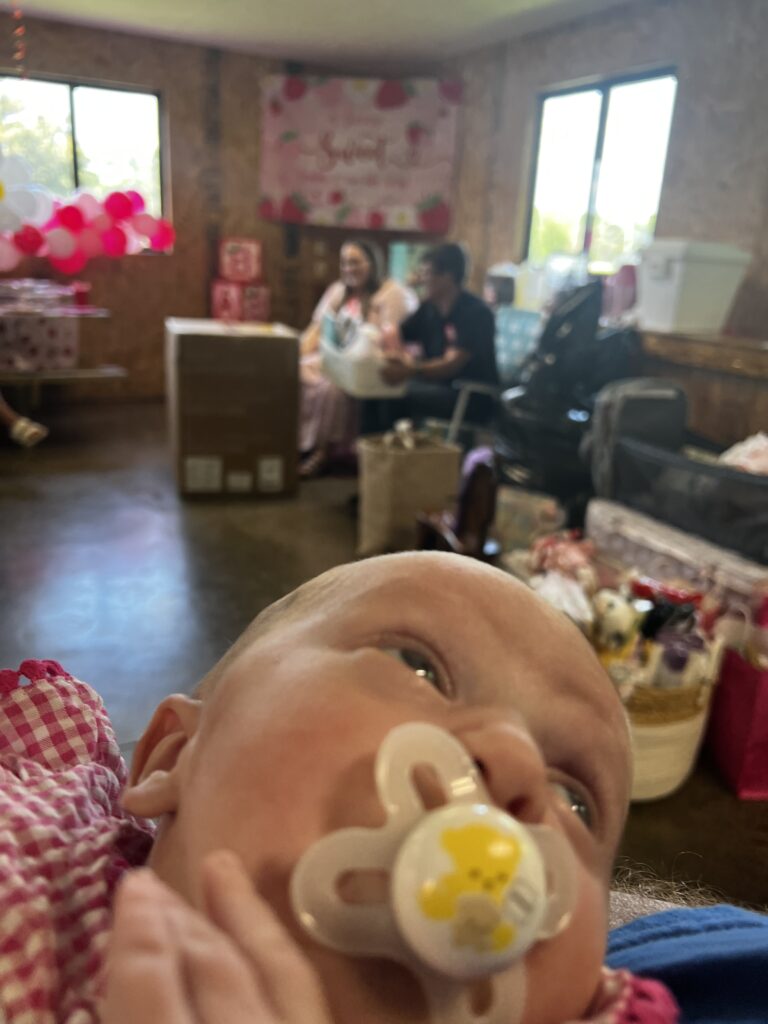 Winsley (Winnie) baby with Marla and Glenda smiling in the background at the baby shower.