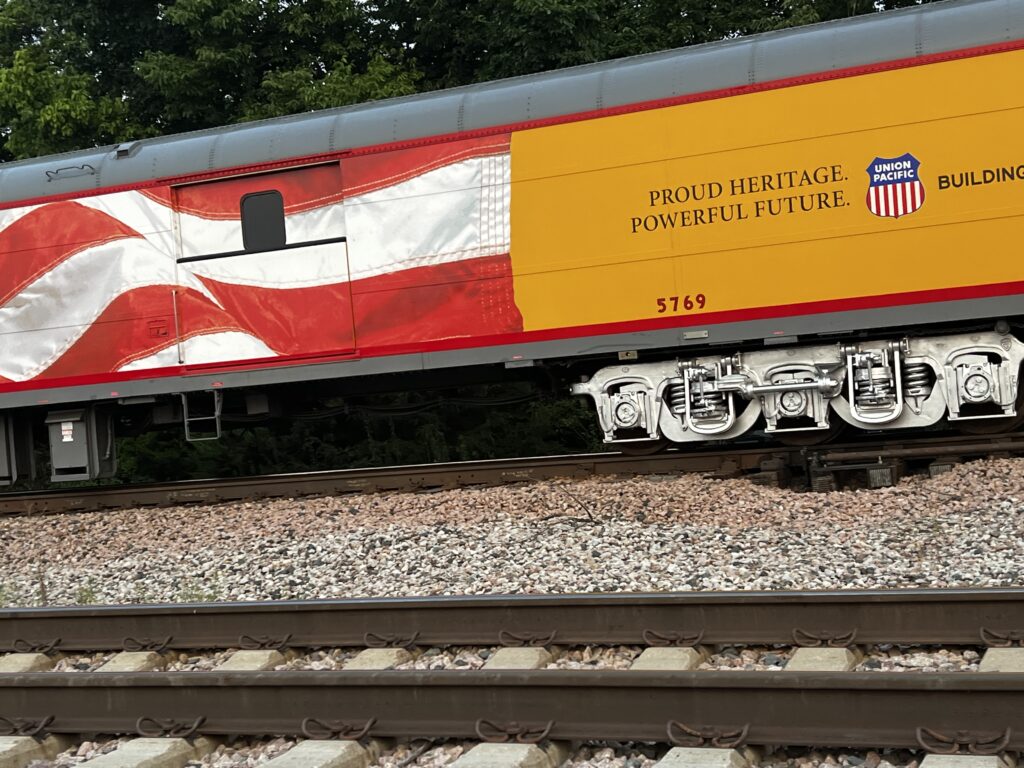Union Pacific railcar with American flag near Paola, Kansas railroad corridor