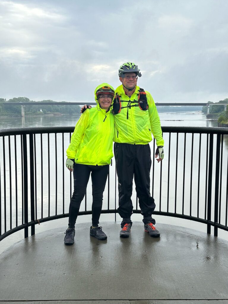 Cyclists Dave and Kara standing at the Boonville lift bridge overlooking the Missouri River on the Katy Trail.