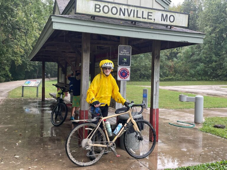 Randy standing at Boonville Trailhead on the Katy Trail, wearing a raincoat and soaked from rain.