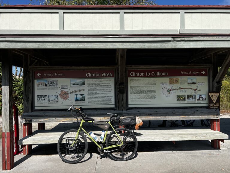 Bike parked in front of the Clinton Trailhead sign on the Katy Trail, ready to start the ride to Sedalia.