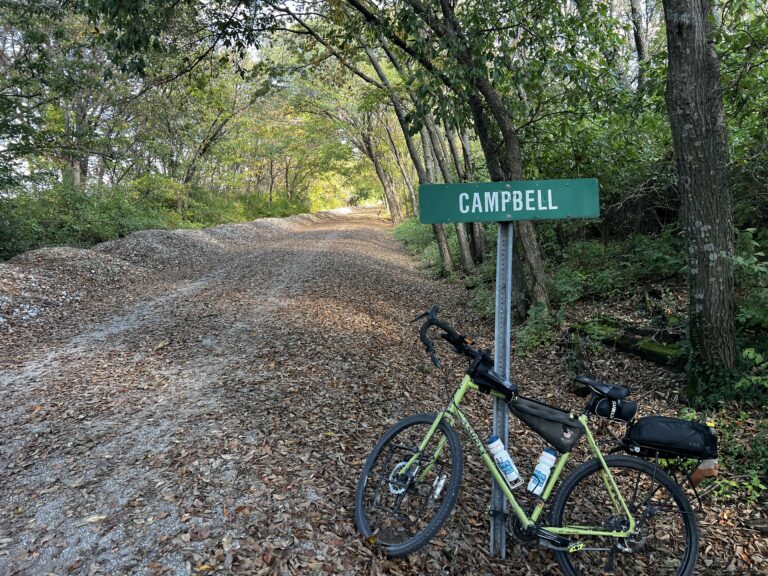Cyclists’ bike leaning against the “Campbell” sign on the Katy Trail, near Sedalia, Missouri.