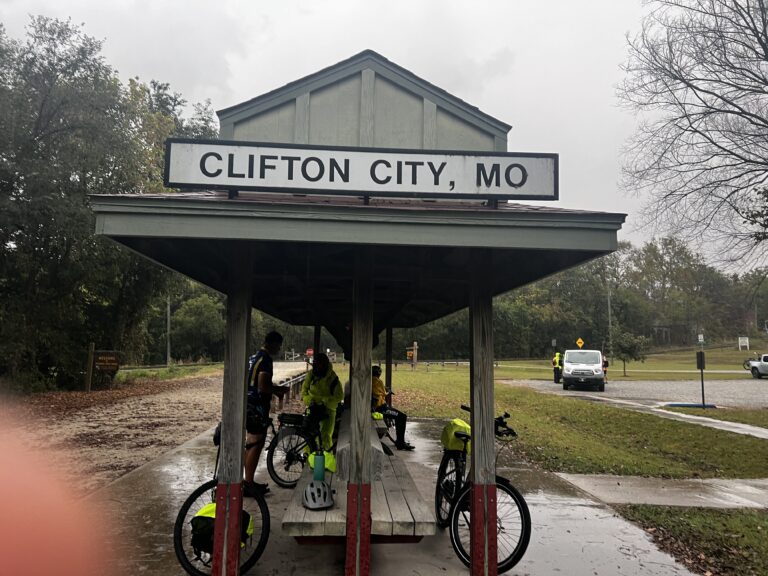 Cyclists gathered at the Clifton City Trailhead on the Katy Trail in the rain.