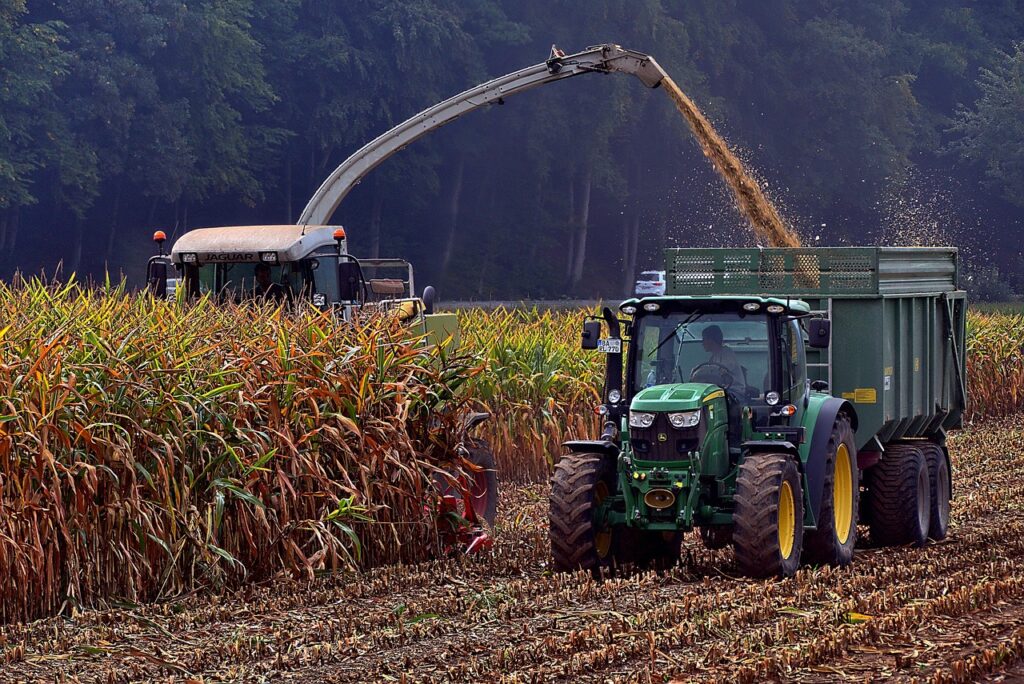 Tractor harvesting corn in a field during September Corn Moon.