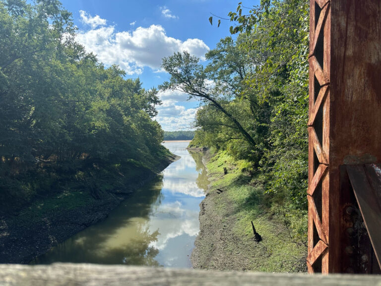 Lost Creek flowing toward the Missouri River, surrounded by trees, captured on a ShauneNation bike ride